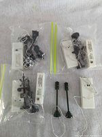 Overview of three bagged crossing signals with battery packs, two green lamp posts and one extra battery pack