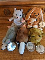 Group shot of five Coca-Cola plush animals showing tags and flags