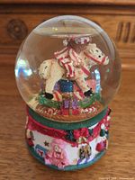 Front view showing teddy bear on rocking horse inside globe and decorated base