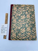 Front cover showing marbled boards and cloth spine with scale ruler