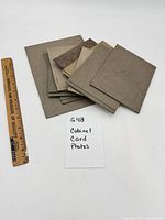 Stack of cabinet card folders beside ruler for scale