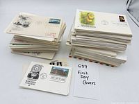 Two stacks of first day cover envelopes beside label handwritten G37 First Day Covers