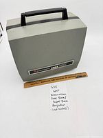 Projector closed with carry handle, ruler for scale