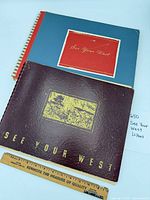Two spiral-bound See Your West albums with ruler for scale