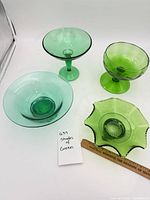 Group of four green glass dishes showing variety
