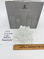 Crystal waterlily in front of branded box with ruler for scale