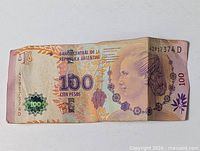 Front of Argentine 100 pesos note showing Eva Perón portrait, denomination, serial number