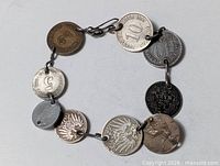 Entire bracelet laid flat showing all ten coins and clasp
