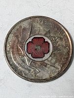 Reverse showing red poppy within maple leaf and armistice dates