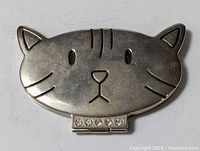 Front view of cat-shaped compact mirror showing facial design and rhinestone hinge