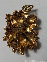 front view of gold-plated nugget pendant showing textured design