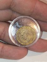 Obverse of 1942 Canada tombac 5-cent coin showing King George VI in protective capsule, hand for scale