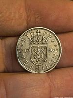 Reverse of 1956 One Shilling coin, shield with lion, inscriptions