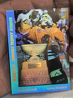 Front holographic side of card in sleeve showing trophy and player