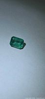 Octagon-cut green emerald loose stone front view