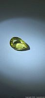 Pear cut lemon citrine on neutral background, full gemstone view