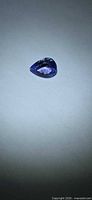 Pear-shaped violet-blue tanzanite on light background
