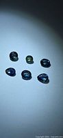 Six loose sapphires on neutral background