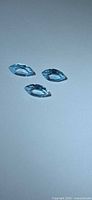 Three marquise sky blue topaz stones on neutral background