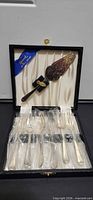 Open presentation box showing all six forks in plastic sleeves and cake server in lid