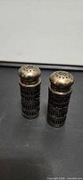 Front view of both sterling silver lattice salt and pepper shakers