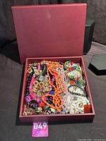 Burgundy box filled with assorted jewellery pieces