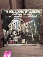 Front cover showing album title, band name, venue photo, sealed shrink, lot tag visible