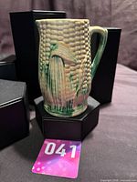 Front view of majolica corn pitcher showing relief kernels and handle