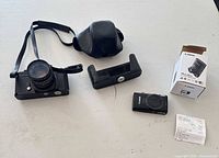 Overall lot showing both cameras, case, grip, box and receipt on table