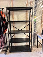 Full view of black metal shelving unit showing all five shelves and frame
