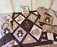 Full bedding set laid out showing quilt, pillow, crib skirt, bumpers, organizer