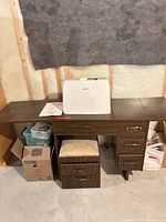 Sewing cabinet with stool, machine cover and accessories visible
