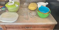 All items on countertop showing salad spinner, microwave steamer set, mixing bowls, measuring bowls and glass bowls