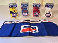 Four boxed bears and blue Pepsi apron displayed