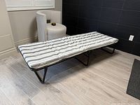 Folding bed fully extended showing cushion and frame