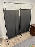 Two freestanding privacy panels side by side in front of closet doors