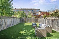 patio set showing loveseat and two club chairs on artificial grass yard