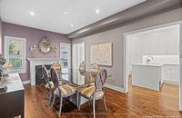 Dining table with six chairs around, showing glass top and chair upholstery