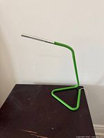 Full view of green IKEA Harte LED desk lamp on table