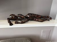 Full view of welded metal reclining figure sculpture