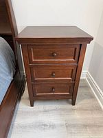 Front view of left nightstand showing drawers and knobs