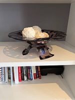 oblique view of bowl on shelf with decorative balls