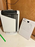 Front view of Fellowes AeraMax air purifier standing next to boxed CRC 93205 HEPA filter