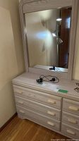 Front view of light wood laminate dresser with attached framed mirror