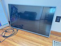 Front view of LG 43-inch TV leaning against wall