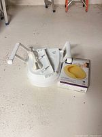 All three aids: toilet riser with arms, grab bar, boxed bedpan