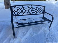 Full front view of black metal bench in snow