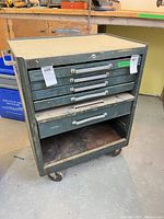 Front view showing five drawers, empty slot, casters