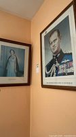 Both framed portraits hanging on wall, showing scale and frames