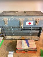 Front view of closed blue-grey metal toolbox with drawers